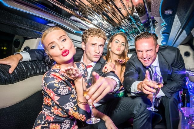 two couples having champagne and party at the back seat of a luxury stretch limousine owned by Limo Hire Melbourne
